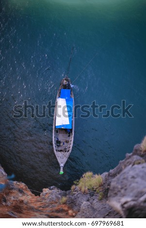 ?High rise picture of blue and white roof long tail boat floating waiting for a customer on the water in Krabi province, Southern of Thailand.