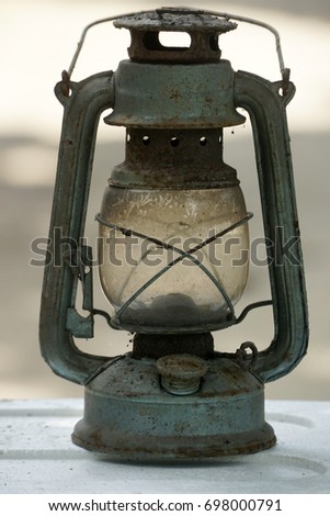 An old rusty oil lamp. Shallow depth of field, low light condition and selective focus.