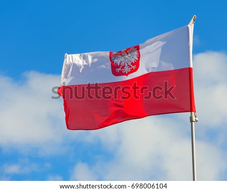 Polish flag with emblem of white eagle.