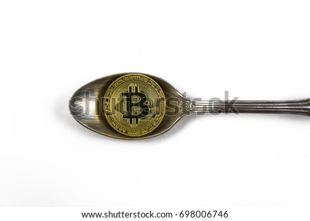 golden bitcoin on silver spoon