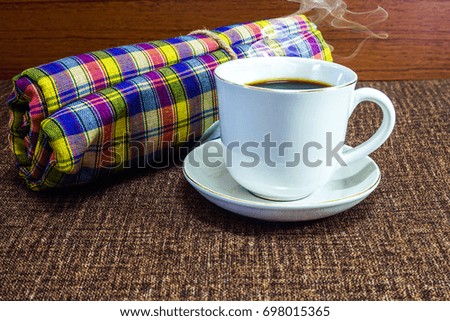 A cup of coffee on an old kitchen table and dessert.