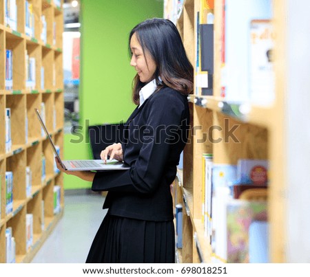 Young business people are using their free time to relax and find information in a library happily. Selective Focus
Use laptop to find information in library. Work comfortably using a laptop