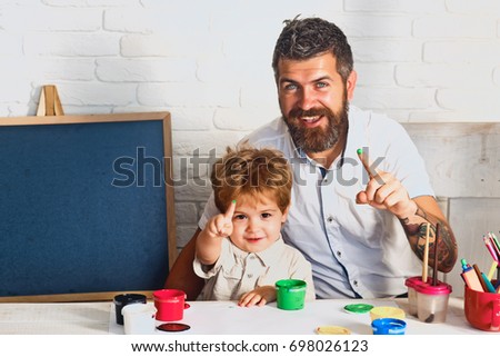 Father son show green fingers from paint for drawing. Family draws together. Art teacher and schoolboy. Finger paint. Drawing for children. Bearded artist and little boy are happy about paints