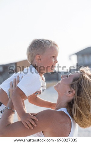 Happy family relaxing by the sea. Happy family resting at beach in summer. mother with baby boy resting on the beach. Young mother and her adorable little son on beach vacation