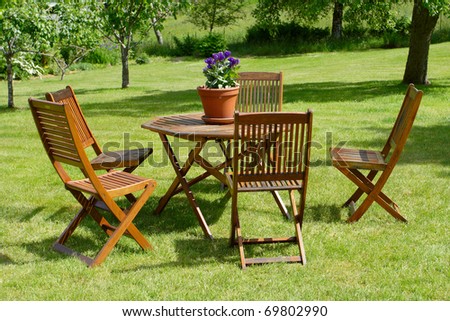 table and chairs standing on a lawn at the garden