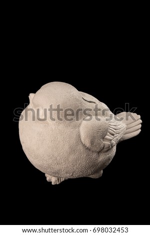 Gypsum statue of a money box of a white bird on a black background