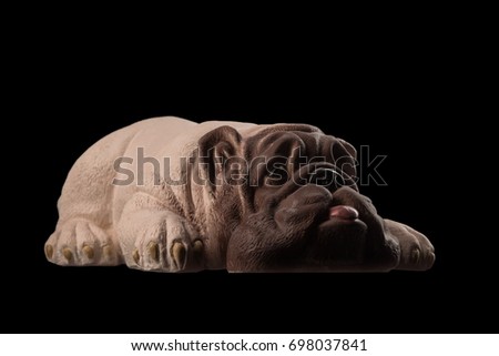 Gypsum sculpture statue of a dog pug bulldog on a black background