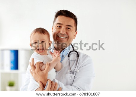 medicine, healtcare, pediatry and people concept - happy doctor or pediatrician holding baby on medical exam at clinic Royalty-Free Stock Photo #698101807
