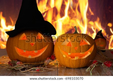 holidays, halloween and decoration concept - carved pumpkins on table over fire background