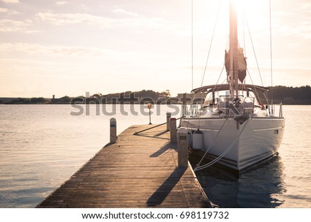 Sailing yacht moored to the pier at sunset