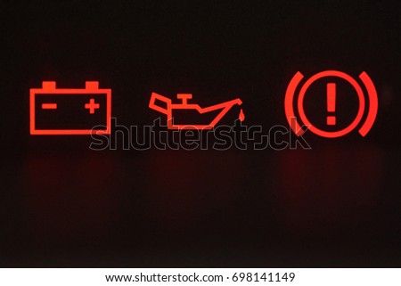 Macro of error signs in car. Red icons of battery, oil and hand break