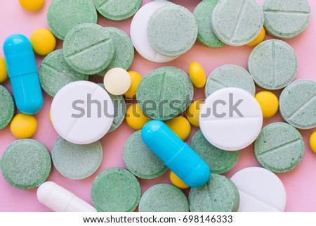 Opioid Pills. Opioid epidemic and drug abuse concept. Different tablets, pills, capsule on a pink background.  Heap mix therapy drugs.  Royalty-Free Stock Photo #698146333