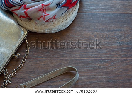 Handbag for women and lightweight shawl on a wooden dark background. The view from the top. The concept of fashion and design