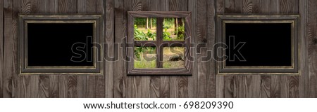 Wooden wall with empty photo frames and forest outside the window. Copy space. 