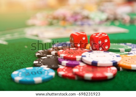 Chips are like money in a casino, placed on a green table as a symbol of the coin used to bet on a casino.Concept about entertainment and gambling