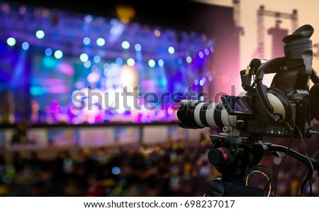 Video production covering event on stage by professional video camera in outdoor concert at sunset Royalty-Free Stock Photo #698237017