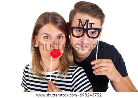 Picture of a happy couple posing with photobooth accesories on isolated background