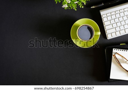 Office leather dark desk table with computer, supplies and coffee cup. Top view with copy space
