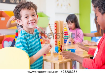 Kindergarten students smile when playing toy in playroom at preschool international,education concept. Royalty-Free Stock Photo #698288386
