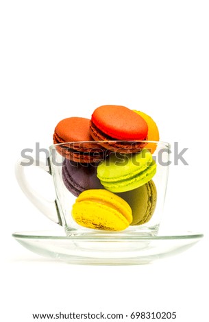 Colorful sweet macarons in a glass on white background