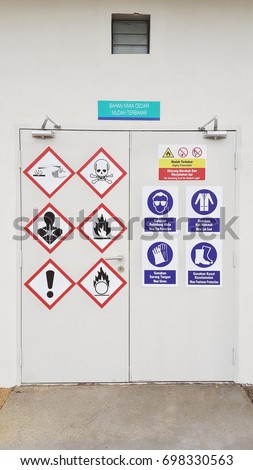 Hazard and safety sign  on door in English and Malay language. 
