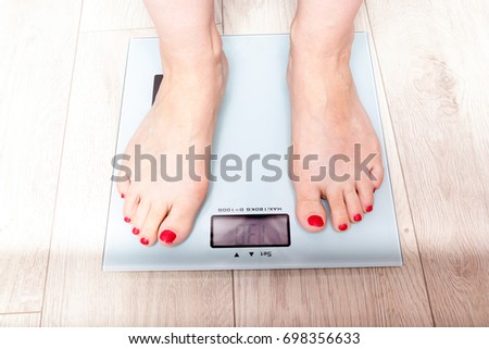 Female bare feet standing on a digital scales. Weight loss
