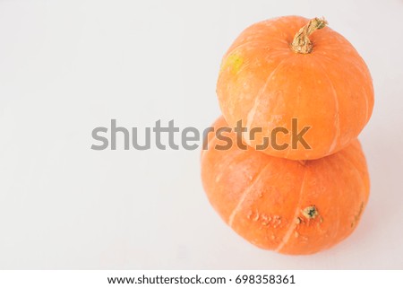 Two stacked mini pumpkins on white background. Studio shot of orange pumpkins on wooden table