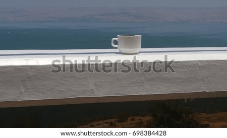 white cup of hot coffee at the balcony