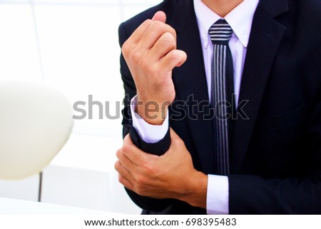 Office syndrome man is massaging his arm. He is suffering from using computer too long