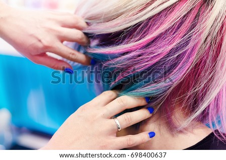 Hairdressers hands in colorful client head and hair after coloring or hair dyeing. Royalty-Free Stock Photo #698400637