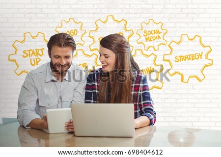 Digital composite of Happy business people at a desk looking at a tablet and a computer against white wall with yellow gr
