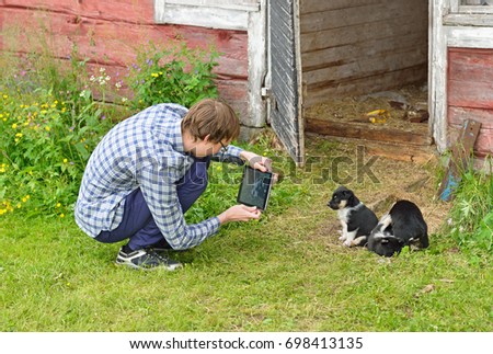 Young man shoots puppies with tablet 