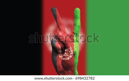 afghanistan national flag painted onto a male hand showing a victory, peace, strength sign
