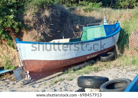 Fisher boat on the beach by the sea at sunset time. Summer concept.