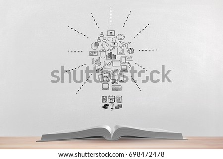 Digital composite of Book on the table against white blackboard with bulb graphic