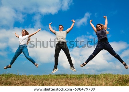 group of happy friends jumping high outdoors