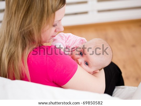 Young mum holds on hands of the chest baby