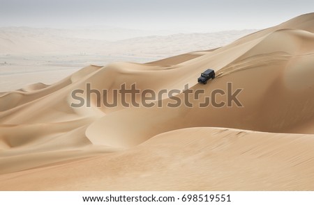 car driving in Rub al Khali Desert at the Empty Quarter, in Abu Dhabi, United Arab Emirates Royalty-Free Stock Photo #698519551