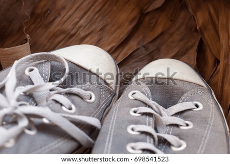 Old shoes on dry banana leaf.