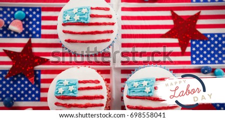 Digital composite image of happy labor day text with blue outline against cupcakes on american flags