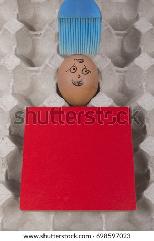 Cartoon face expression at egg and red board with finger also plastic brush