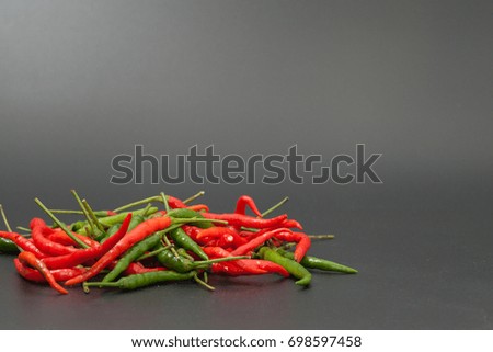 red and green chilli hot pepper on black background