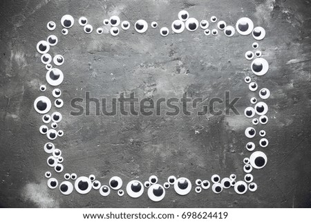 Halloween background with eyeballs frame on dark stone background