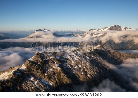 Aerial landscape view of the remote mountains covered in low level clouds. Picture taken near Squamish, North West of Vancouver, British Columbia, Canada.