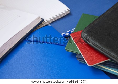 notebooks, folders, notebook paper, lay on a purple background