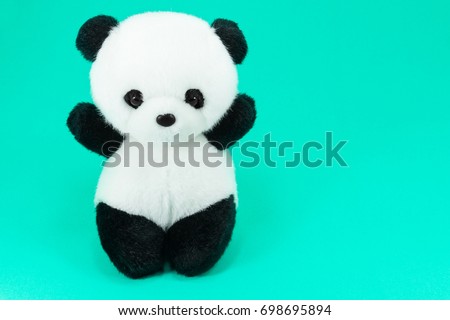Panda doll black and white, black rim of eyes,panda toy for children on green background