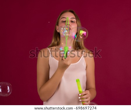 Young cute girl blows bubbles, pretty woman