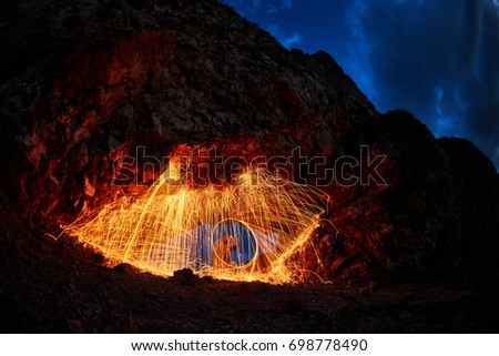 eyes are painted burning steel wool in the mountain
