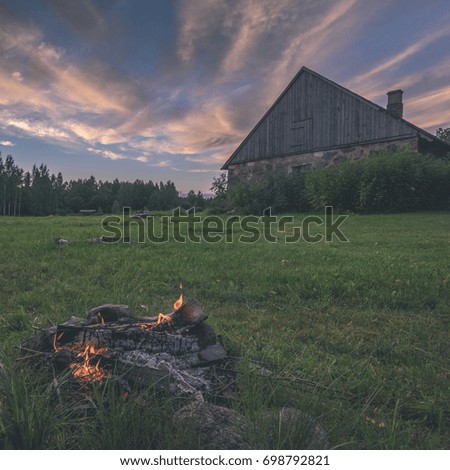 dramatic sunset over countryside in summer with house and fire place - vintage film look