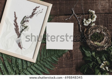 wedding invitation mock-up and rustic boutonniere under glass frame on wooden  background with fern leaves. rustic barn wedding concept. top view. flat lay, empty card